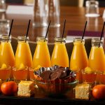 Selection of cakes, sweets and small bottles of orange juice lined up for a meeting at Mercure Hotels