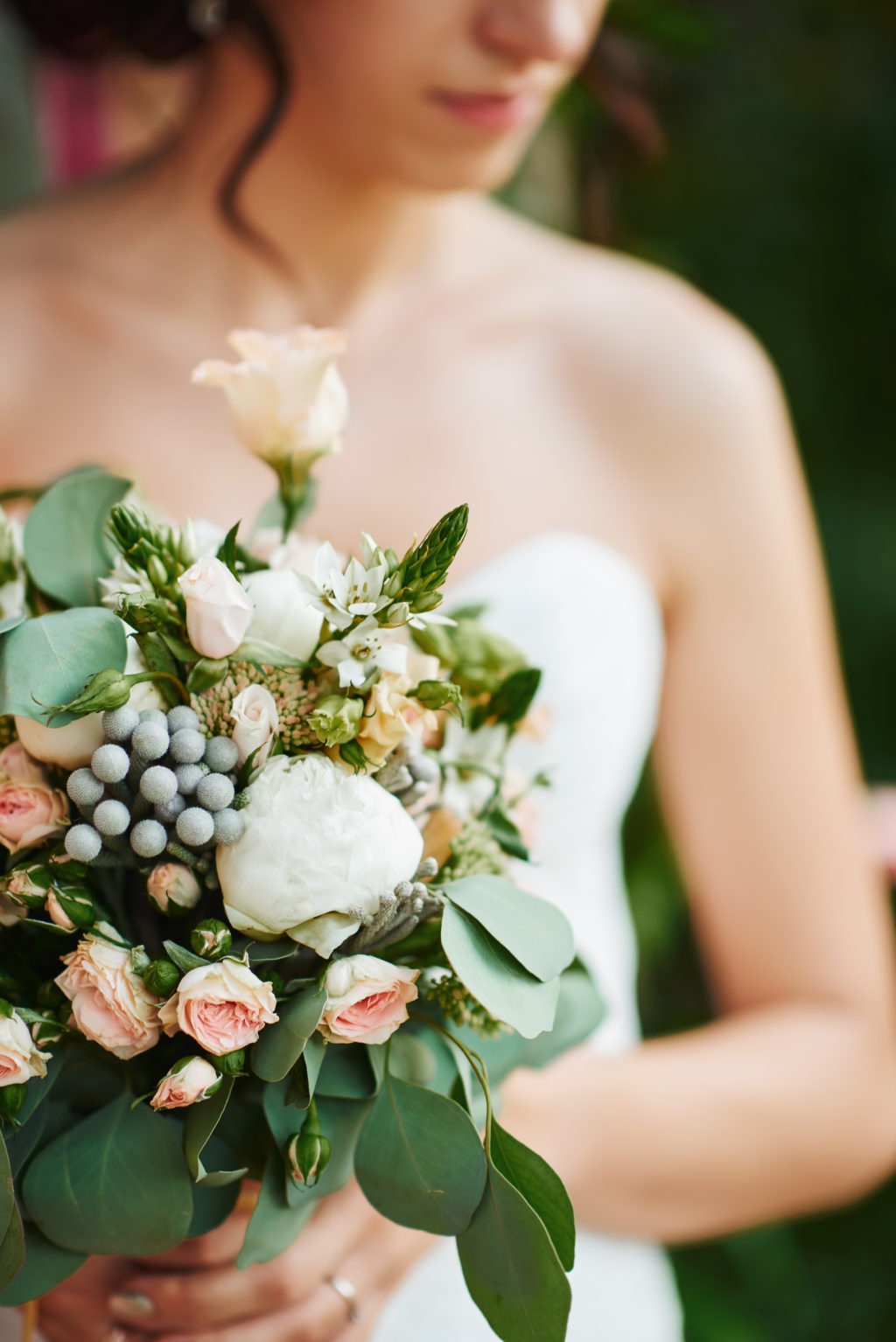 Bridesmaid with a white dress holding a wedding bouquet