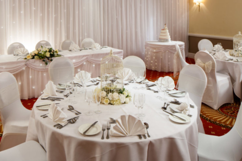 Tables set for an ivory wedding theme in the garden suite at the mercure hull grange park hotel